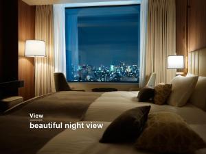 a bedroom with a large bed with a view of a city at Mitsui Garden Hotel Roppongi Tokyo Premier in Tokyo