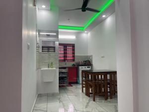 a kitchen with a green light on the ceiling at Rainbow apartments in Cochin