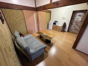 a living room with a couch and a coffee table at Sakurahome&El Flamenquito in Muroto