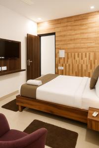 a bedroom with a large bed and a tv at Vinayaka in Patna