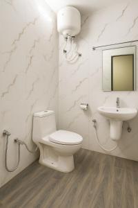 a bathroom with a toilet and a sink at Vinayaka in Patna