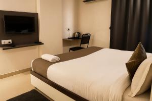 a hotel room with a bed and a television at Vinayaka in Patna