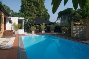 a large blue swimming pool in front of a house at Villa Escondite - The Hotel in Sri Jayewardenepura Kotte