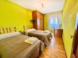 La senda del torio : سريرين في غرفة بجدران صفراء