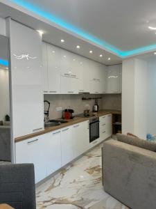 a kitchen with white cabinets and a couch at Stan na dan Arte in Loznica