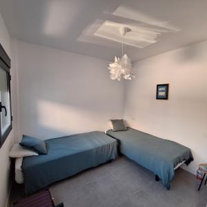 a bedroom with two beds and a chandelier at Chilches Sunset Beach in Vélez-Málaga +31 photos