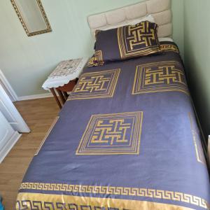 a bed with a purple bedspread and two pillows at Single Bedroom in the main Bungalow in Wednesfield