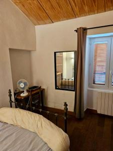 a bedroom with a bed with a mirror and a window at Maison de charme avec Terrasse vue sur mer in Rogliano