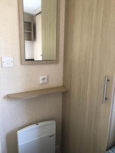 a bathroom with a medicine cabinet and a toilet at Mobilhome spacieux et calme in Pont-Aven +12 photos