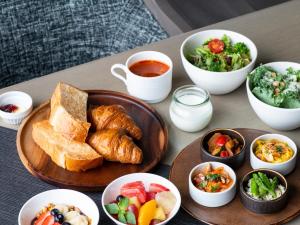 a table with a plate of bread and bowls of food at Mitsui Garden Hotel Roppongi Tokyo Premier in Tokyo +52 photos