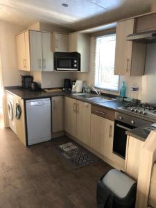 a kitchen with a sink and a stove top oven at Mobilhome spacieux et calme in Pont-Aven