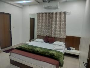 um quarto com uma cama grande com janela em Hotel Vista Haven em Patna mais 6 fotografias