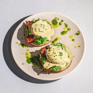 a plate with two sandwiches with sauce and broccoli at Casa Weidner in Sibiu