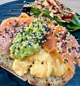 a blue plate with a bagel sandwich with a salad at Casa Weidner in Sibiu +23 photos