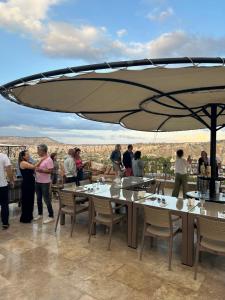 a group of people standing around a table with an umbrella at Virtus Cappadocia Hotel Göreme in Goreme