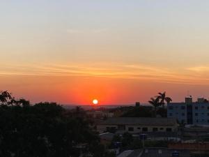 a sunset over a city with the sun in the sky at Apartamento automatizado valparaiso in Valparaíso de Goiás