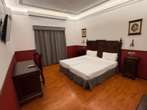 een slaapkamer met een bed en een tafel erin bij Hotel El Cisne in Zaragoza