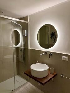a bathroom with a sink and a glass shower at Seraphia Apartment in Palermo