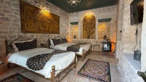 a bedroom with two beds and a fireplace at Liora Hotel in Urfa