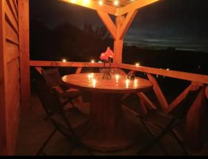a wooden table on a porch with candles on it at Du poil à la plume in Saint-Mards-en-Othe