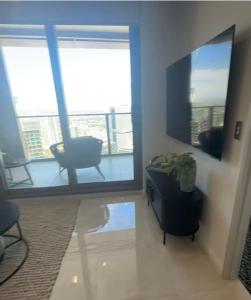 a living room with a tv and a chair and a table at Meriton Parramatta in Sydney