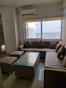 a living room with a couch and a large window at My Private Space in Ludhiana