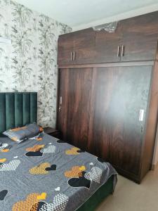 a bedroom with a bed and a large wooden cabinet at My Private Space in Ludhiana