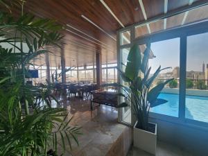 a room with a large window and a pool at Mar Charbel Hotel Cairo in Cairo
