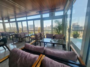 a room with glass walls and tables and chairs at Mar Charbel Hotel Cairo in Cairo