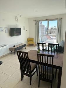 a living room with a wooden table and chairs at Belgrano Apart in Comodoro Rivadavia +8 photos