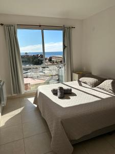 a bedroom with a bed and a large window at Belgrano Apart in Comodoro Rivadavia
