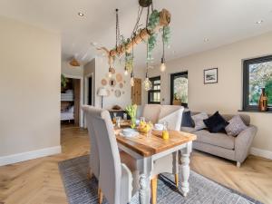a dining room and living room with a table at Bwythyn Cudd in Manortown