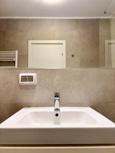 a white sink in a bathroom with a mirror at Sunshine Luxury Apartment Private Parking in Cluj-Napoca