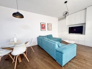a living room with a blue couch and a table at Sunshine Luxury Apartment Private Parking in Cluj-Napoca