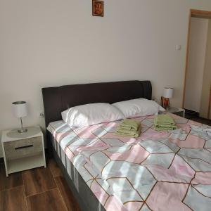 a bedroom with a large bed with two pillows on it at Apartman5 in Gornja Toplica +11 photos
