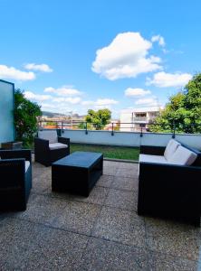 een patio met banken en tafels op een dak bij T2 avec terrasse & garage privé, Proche Jaude in Chamalières