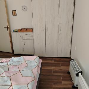 a bedroom with a bed and cabinets and a fan at Apartman5 in Gornja Toplica +4 photos