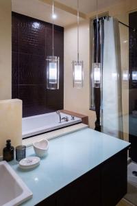 维罗纳SWEETHOME DOMUS 250mq nel centro di Verona con vista sul Teatro Romano的带水槽和浴缸的浴室