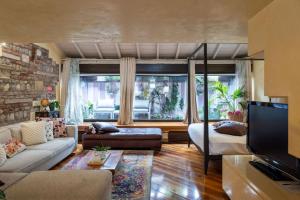 维罗纳SWEETHOME DOMUS 250mq nel centro di Verona con vista sul Teatro Romano的客厅里有一张沙发和一台电视