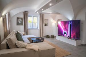 a living room with a couch and a large screen tv at Premium Apartment Landshut Altstadt 100" TV Gaming Tiefgarage in Landshut