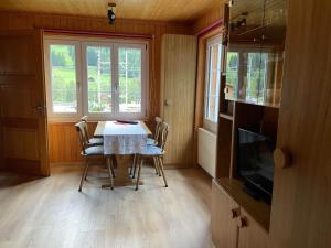 een eetkamer met een tafel, stoelen en een televisie bij Haus Bortis in Niederwald