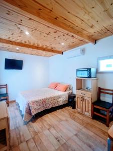 een slaapkamer met een bed en een houten plafond bij La casita de Bonsai in Chapadmalal