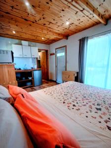 een slaapkamer met een groot bed en een keuken bij La casita de Bonsai in Chapadmalal