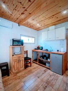 een keuken met witte kasten en een houten plafond bij La casita de Bonsai in Chapadmalal