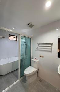 a bathroom with a toilet and a glass shower at Proud Chiang Mai Poshtel in Chiang Mai