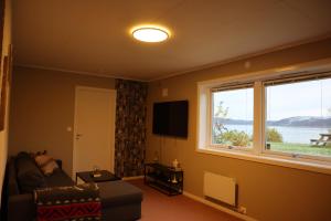 トロムソにあるNordic Sauna Retreatのソファと大きな窓のあるリビングルーム