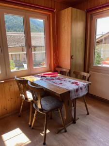 een eetkamer met een tafel, stoelen en ramen bij Haus Bortis in Niederwald