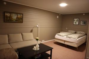 a living room with a couch and a bed at Nordic Sauna Retreat in Tromsø