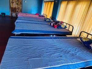 three beds are lined up in a room at Ceylon Grand Airport Tourist Accommodation in Katunayake