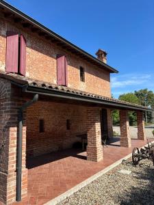 a brick building with red doors and a brick patio at Agriturismo Varana in Zibello
